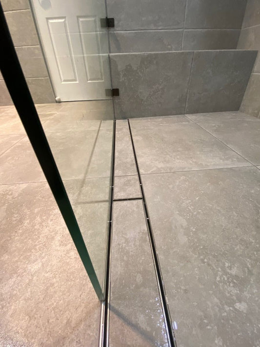 Tile insert drain in bathroom shower.