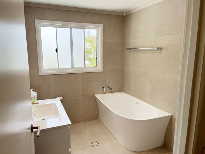 Square tile insert drain installed in customer bathroom.